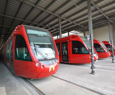 Tram cars sit idle in the station.